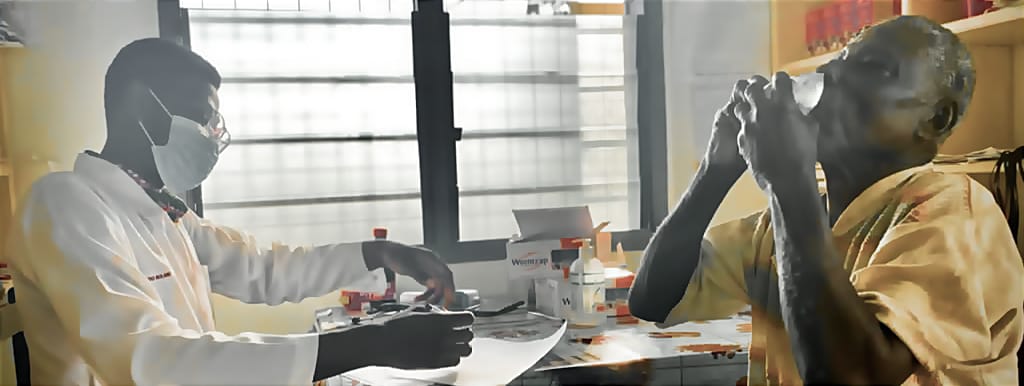 Helping a farmer deworm in Ghana, farmer drinking water after taking albendazol 400mg as a single dose